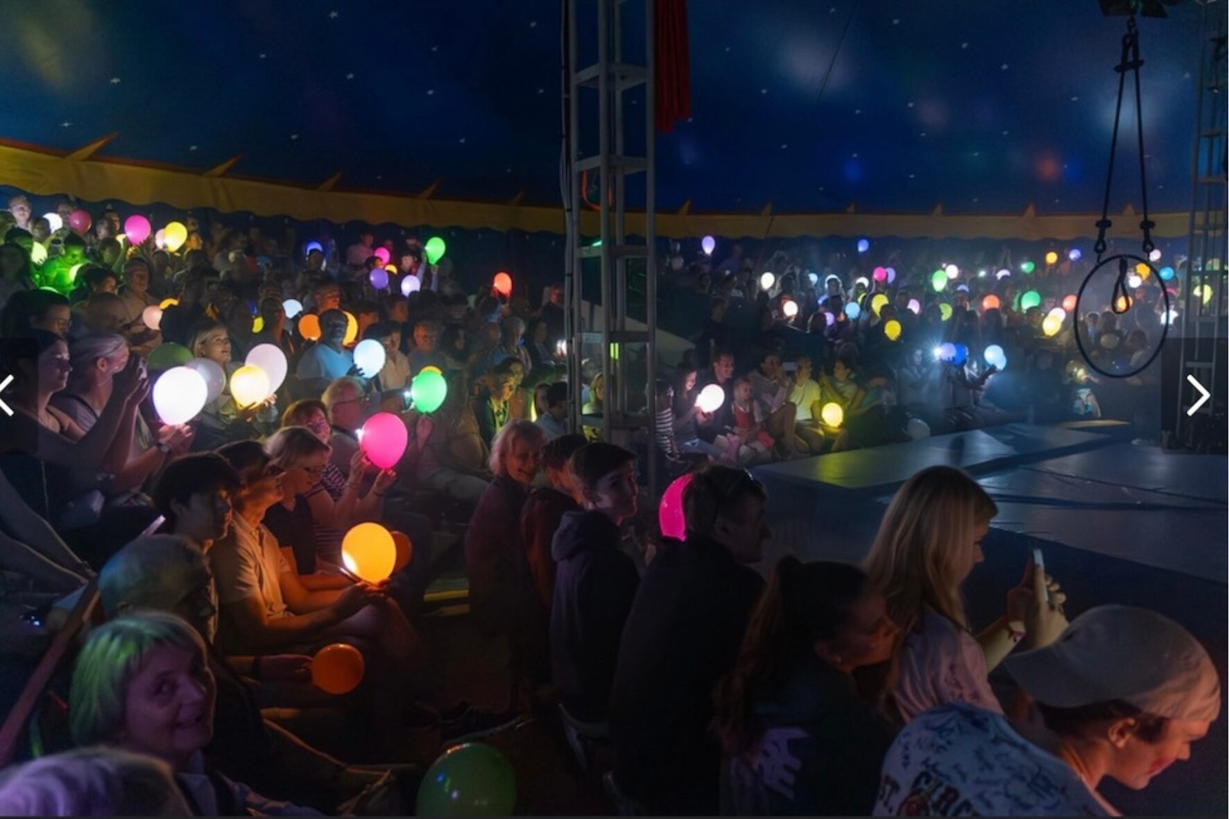 Publikum mit leuchtenden LED-Ballons im Zelt des Circus St. Ottilien, Rhabanus-Maurus-Gymnasium