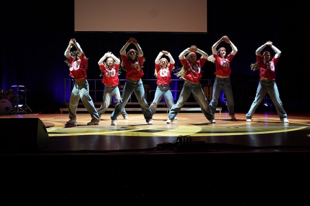 Hip-Hop-Tanzgruppe mit erhobenen Armen in roten Trikots, Best of Schulwerk