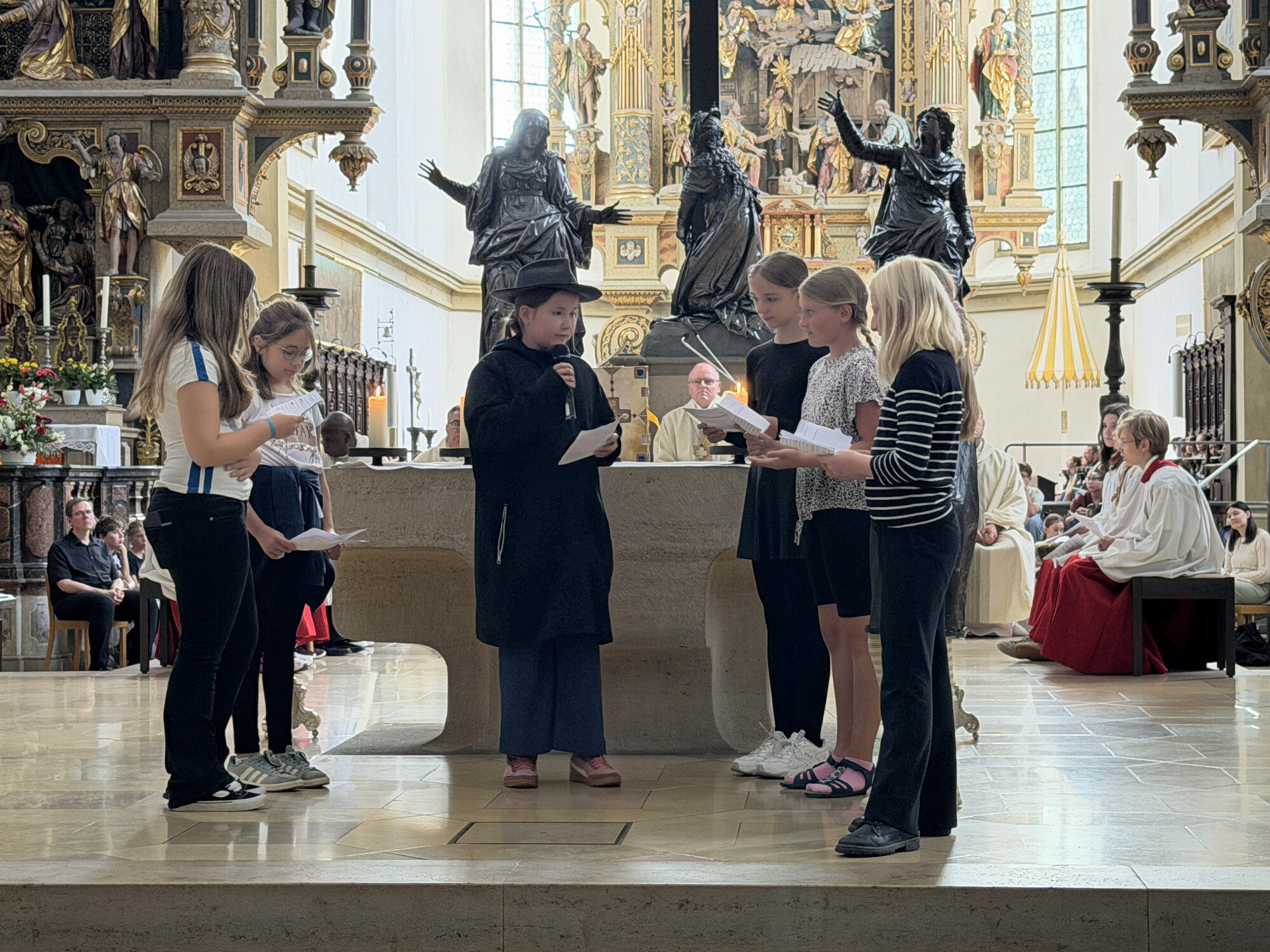 Schülerinnen spielen die Geschichte des heiligen Ulrich beim Pontifikalamt der Ulrichswoche