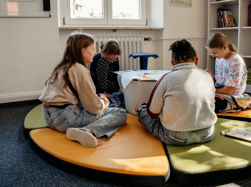 Schüler beim maßgeschneiderten Lernen auf dem Boden, ULI Augsburg